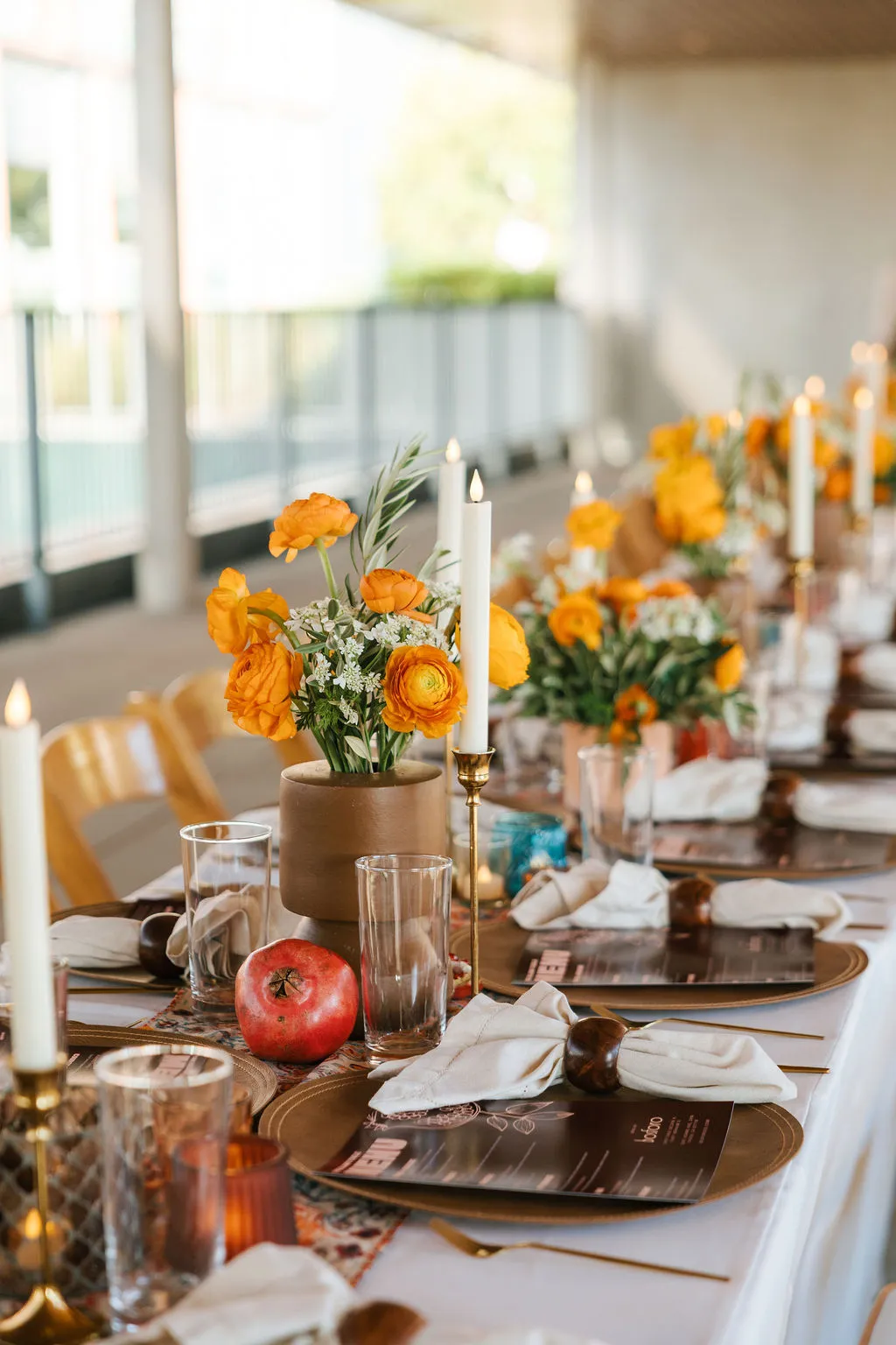 Dinner table with candles, pomegranates and flowers