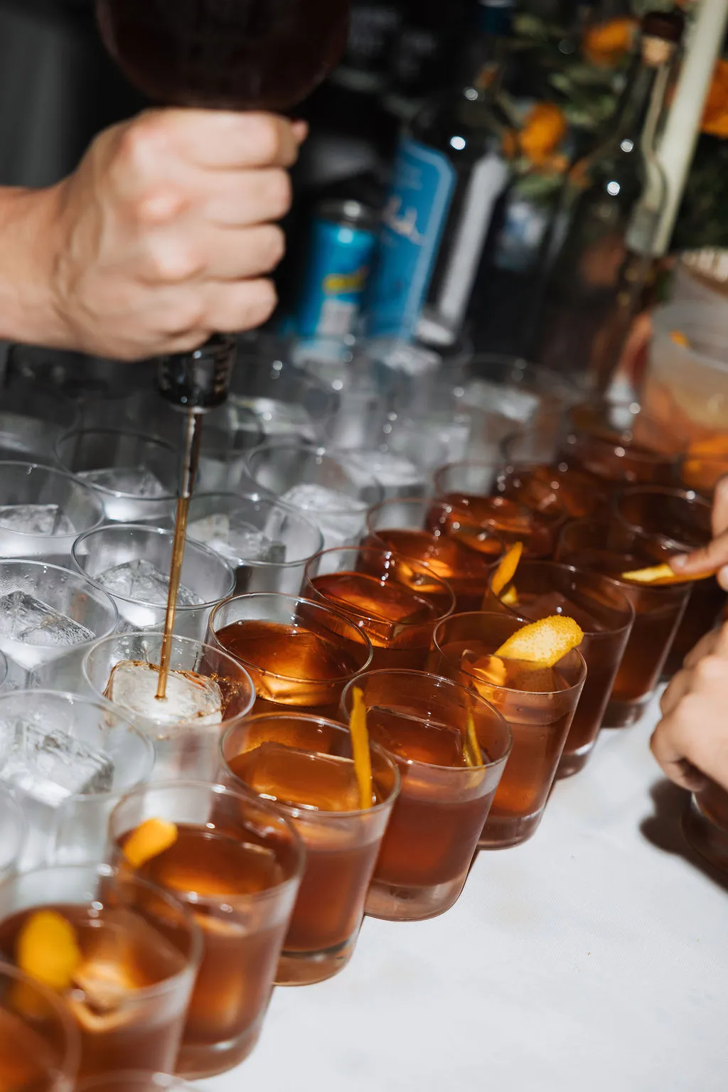 A bartender pouring cocktails over ice