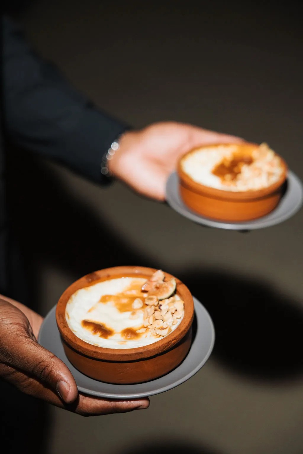 Two warm desserts served in clay dishes