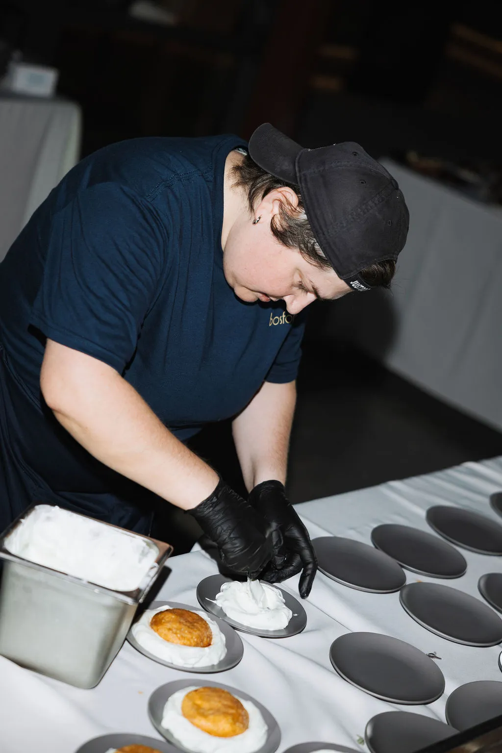 A cook carefully plating desserts at a catered event